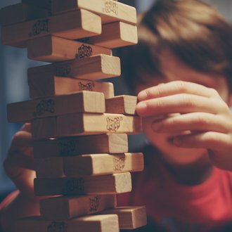 Ein kleiner Junge der das Jenga spielt